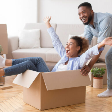 Excited,African,American,Man,Riding,Woman,In,Cardboard,Box,Celebrating